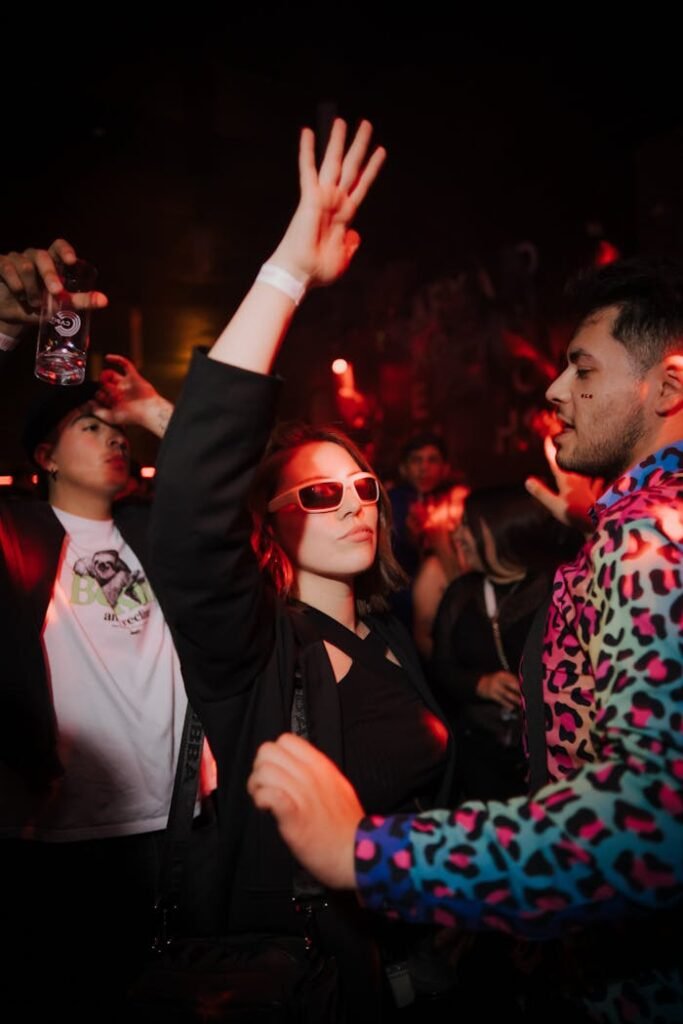 Galería Young adults enjoying a vibrant nightlife party in Concepción. Energetic dancing and colorful atmosphere.