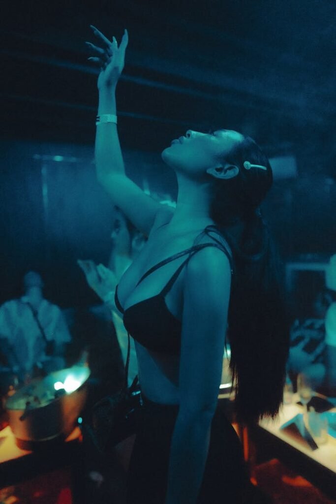 Galería Young woman dancing energetically in a vibrant nightclub setting, capturing joyful nightlife vibes.