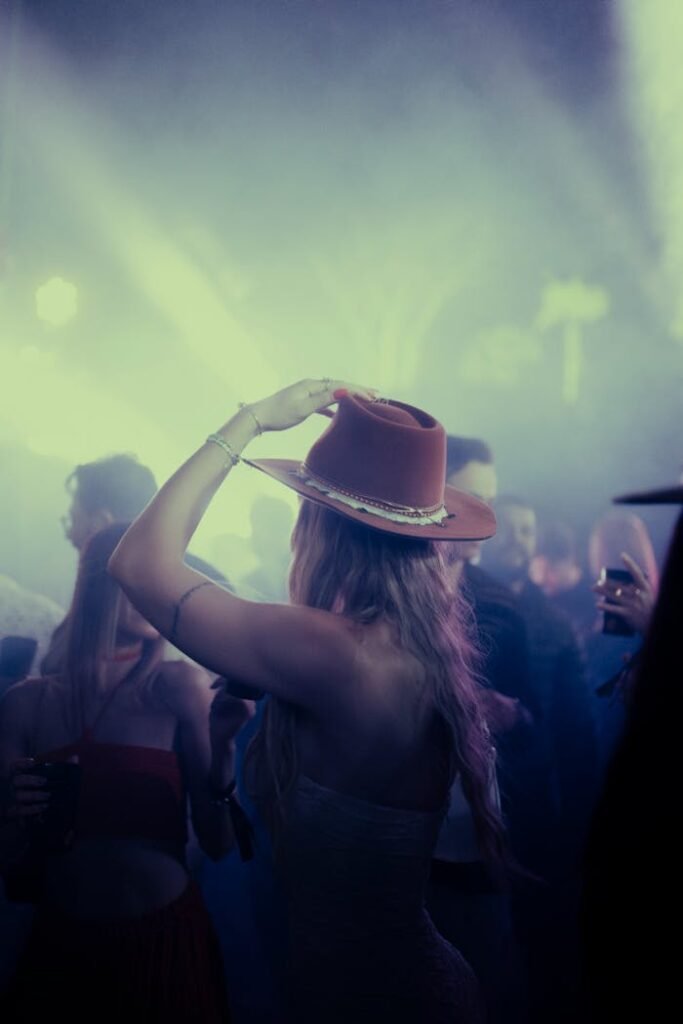 Galería Chic gathering with people dancing under dramatic lights at night party.